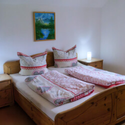 Schlafzimmer Ein Bild, das ein Doppelbett aus Holz zeigt.